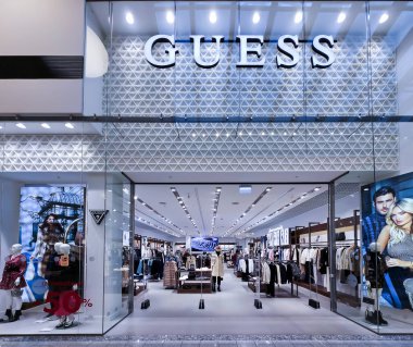 LATVIA, RIGA, 25, HAZİRAN, 2024: Riga 'daki Akropole alışveriş merkezindeki Guess büyük mağazasının modern içi. - Letonya. Sanırım kot markasıyla tanınan lüks bir Amerikan giyim markası..