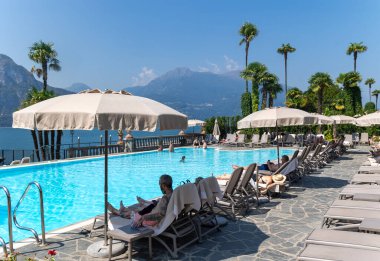 İtalya, BELLAGIO, COMO Gölü, 26, AUGust, 2023: Grand Hotel Villa Serbelloni, Alpler 'in arka planında yüzme havuzu bulunan tarihi lüks otel. İtalya.