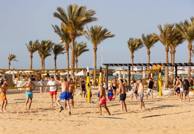EGYPT, HURGHADA, 20, APRIL, 2024: Turistler Hurghada 'daki Steigenberger ALDAU Oteli' nin Kızıl Deniz kıyısındaki kumlu plajda plaj voleybolu oynuyorlar. Mısır