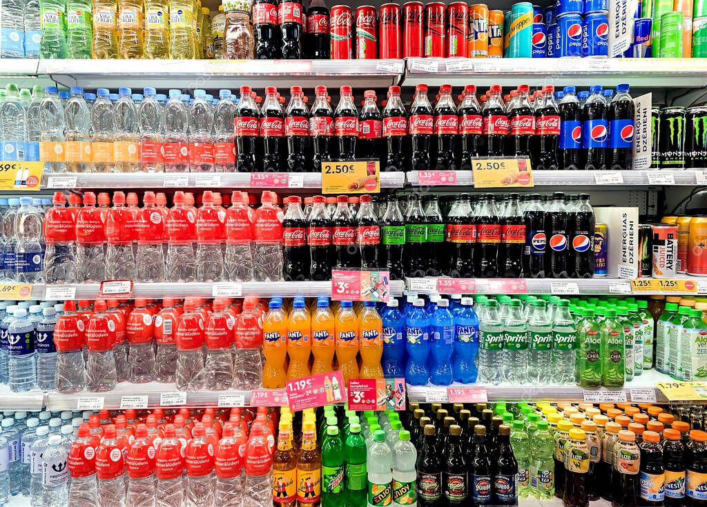 LATVIA, RIGA, 25, MAY, 2024: Coca-cola, fanta, sprite and mineral water bottles on display for sale in supermarket shelf, Riga. Latvia.