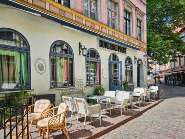 LATVIA, RIGA, 15, HAZİRAN, 2024: Letonya 'nın başkenti Riga' daki Town Hall Square yakınlarında açık hava kafeleri bulunan Riga Old Town 'un Narrow Caddesi
