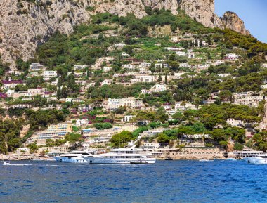 İtalya, Capri, 16 Haziran 2024: İtalya 'nın Campania bölgesinde kıyıya demirlemiş yatları bulunan yeşil Capri adasının lüks manzarası