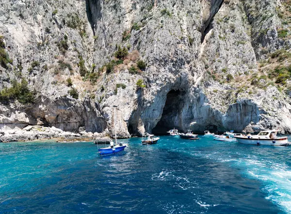 Stock image Italy, Capri, 16, June, 2024: Limestone cliffs with natural arches and caves overgrown with thorny Mediterranean bushes of the Capri island of volcanic origin in the Tyrrhenian Sea, Campania, Italy