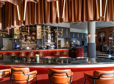 LATVIA, RIGA, JUNE, 25, 2024: Radisson Blu Latvija Konferansı ve Riga 'daki Spa Hotel' de alkollü içkiler ve yüksek bar sandalyeli bir barın modern iç mekanı. Letonya.