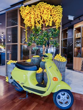 LATVIA, RIGA, 21, HAZİRAN, 2024: Riga 'da yeşil retro scooterlı ve limon sepetli ilginç İtalyan tarzı restoran tasarımı. Letonya.