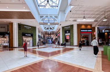 LATVIA, RIGA, JULY, 25, 2024: Daha iyi ışıklandırma için camdan tavanı ve Domina alışveriş merkezinden alışveriş için farklı butikleri olan modern iç mekan, Riga. Letonya