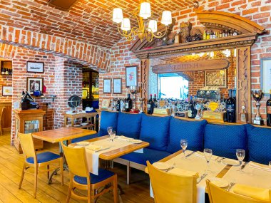 LATVIA, RIGA, AUGust, 15, 2024: Tuğla döşemesi restore edilmiş ve İtalyan mutfağı Riga 'daki Rossini restoranında döşenmiş mobilyalarla samimi restoran içi. Letonya