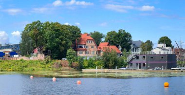 LATVIA, RIGA, KIPSALA, 28 Temmuz 2024: Kipsala, Riga 'daki Daugava nehrinin kıyısında rıhtımlı özel kulübeler. Letonya