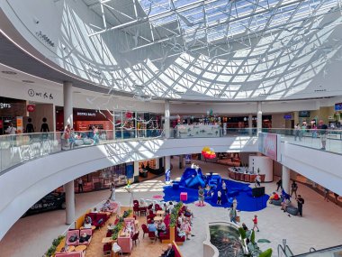 LATVIA, RIGA, 20, AUGust, 2024: Riga 'daki çok katlı Spice alışveriş merkezinde yeniden inşa edildikten sonra cam tavan atriyumuyla modern iç mekan. Letonya