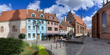 LATVIA, RIGA, 15, AUGust, 2024: St. Johns Kilisesi yakınlarındaki antik gotik mimari, Kuzey Gotik tarzı kırmızı tuğlalı ve Riga Eski Kasabası, Letonya 'nın başkenti Riga' daki Bremen Town Müzisyenleri anıtı.