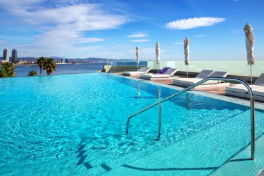 İspanya 'nın Barselona kentindeki Akdeniz kıyılarına bakan turkuaz berrak su ve güneş pansiyonlu açık hava havuzu