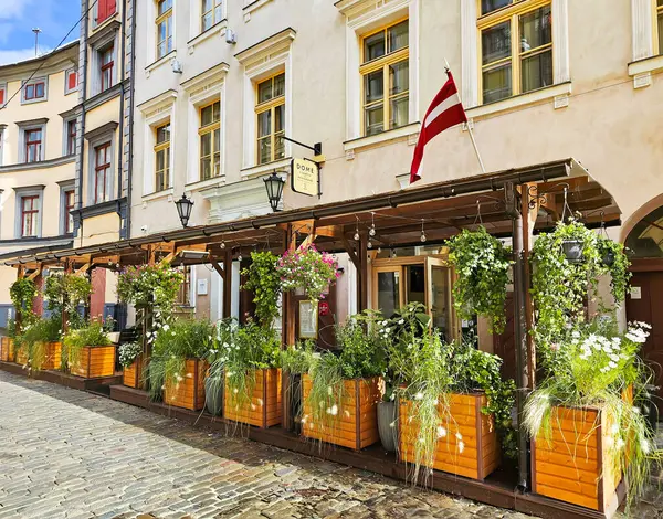 stock image LATVIA, RIGA, AUGUST, 17, 2024: Open veranda with summer flower beds of the Dome restaurant in the Riga Old Town, Latvia