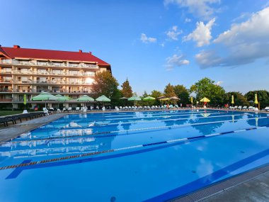 Polonya, Mikolajki, 28 Ağustos 2024: Polonya 'nın Golebiewski otelinde güneşli dinlenme alanlarında soğuk temiz suyla açık hava yüzme havuzu