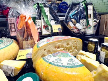 LATVIA, RIGA, SEPTEMBER, 15, 2024: Büyük Hollanda peyniri tekerlekleri ve Riga, Letonya 'da bir süpermarketin şarküteri bölümünde paketlenmiş hediyeler