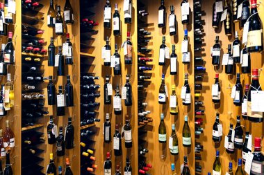 LATVIA, RIGA, SEPTEMBER, 15, 2024: Çeşitli şaraplı ahşap raflar, alışveriş merkezi Riga, Letonya 'da özel fiyatlar. Modern şarap mağazasının içi.. 