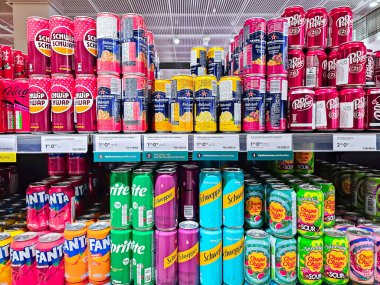 LATVIA, RIGA, SEPTEMBER, 22, 2024: Soda pop drinks on shelves for sale in big food section. The assortment includes Coca Cola, Fanta, Chupa Chups and other drinks. clipart