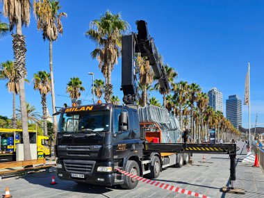 SPAIN, BARCELONA, SEPTEMBER, 25, 2024: A municipal truck is loaded with beach barriers at the end of the summer season at Barceloneta beach. Barcelona, Catalonia, Spain, Europe clipart