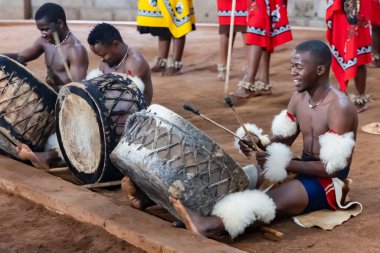 Güney Afrika, Svaziland, 21 Kasım 2024: Geleneksel giysiler içindeki Swati halkı, Mantenga Kültür Köyü 'nde turistler için davul çalıyor..