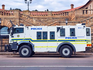 Güney Afrika, Pretoria, 18 Kasım 2024: Güney Afrika hükümetinin Pretoria, Güney Afrika 'daki resmi merkezi olan Birlik Binaları yakınlarındaki camlarında parmaklıkları olan beyaz zırhlı polis kamyonu