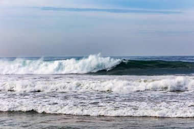 Büyük köpüklü dalgaların kumlu kıyıya çarptığı doğal Hint Okyanusu manzarası. Sri Lanka. Asya