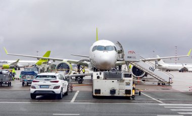 LATVIA, RIGA, MARCH, 15, 2025 - Sabah erkenden uçmaya ve uçağa Riga Uluslararası Havaalanı 'nda bagaj yüklemeye yönelik uçak hazırlığı. Letonya