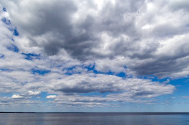 Baltık Denizi 'ndeki sıcak Riga Körfezi' nin manzarası kümülüs bulutlarının arka planına karşı. Letonya 'daki Riga Körfezi kıyıları turistler arasında popülerdir..