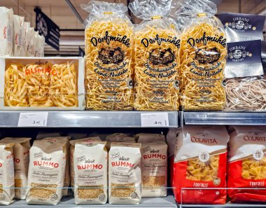 LATVIA, RIGA, JUNE, 18, 2025: Riga, Letonya 'da bir hipermarketin raflarında Alman yumurtalı erişte Dorfmuhle ve İtalyan pastası Colavita ve Rummo