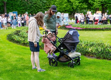 LATVIA, JURMALA, 16 Haziran 2025: Yeşil üzüm, çiçek yatakları ve çocuklu aileler ile güzel şehir parkı Majori, Jurmala 'da kasaba halkını ve turistleri rahatlatıyor. Letonya