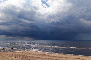 Ufukta, Letonya 'nın Jurmala kentindeki Baltık Denizi üzerindeki bir fırtınadan önce büyük bir gök gürültülü bulut beliriyor.