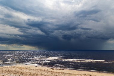 Ufukta, Letonya 'nın Jurmala kentindeki Baltık Denizi üzerindeki bir fırtınadan önce büyük bir gök gürültülü bulut beliriyor.