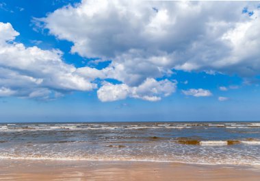 Baltık Denizi 'nde terk edilmiş bir sahil manzarası Jurmala, Letonya' da gökyüzünde kabarık bulutlar var.