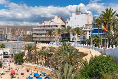 İspanya, BENIDORM, MAYIS, 21, 2025: Benidorm, İspanya 'da antik mimari ve dağların arka planında tatilcilerle Playa del Mal Pas' ın yukarısından görüş.