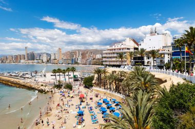 İspanya, BENIDORM, MAYIS, 21, 2025: Benidorm, İspanya 'da antik mimari ve dağların arka planında tatilcilerle Playa del Mal Pas' ın yukarısından görüş.