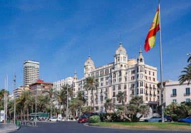 İspanya, Alicante, Mayıs, 18, 2025: Alicante şehir merkezindeki büyük bayrak yakınlarındaki çok katlı binalarla şehir altyapısını ayırmak. İspanya
