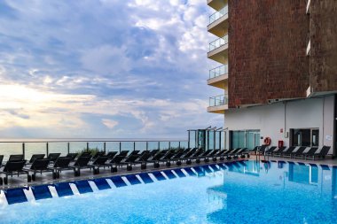 İspanya 'nın Alicante kentindeki Akdeniz' e bakan turkuaz suyu ve sıra sıra güneşlenen ısıtılmış bir yüzme havuzu.