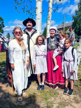 ESTONIA, VARSKA, AUGust, 05, 2025: Geleneksel Seta kostümlü Seta ailesi, Estonya 'nın Varska ilinde düzenlenen Seta Krallığı Günü' nü Estonya 'da bir turistle birlikte kameraya poz verdi