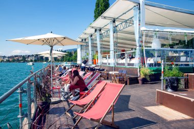 SWitzERLAND, MONTREUX, AĞUSTOS, 28, 2021: Cenevre Gölü, Montreux, İsviçre 'ye bakan güneş pansiyonları ve şemsiyeli kafelerin yaz terasları