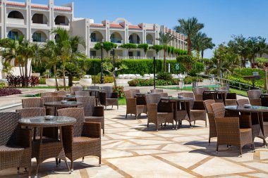 AFRICA, EGYPT, MAYIS, 12, 2021 - Sharm El Sheikh, Mısır 'da Kızıldeniz kıyısında Sunrise Montemare Grand Select otelinde yeşil bahçeli açık hava hasır mobilyaları ile büyük bir avlu.