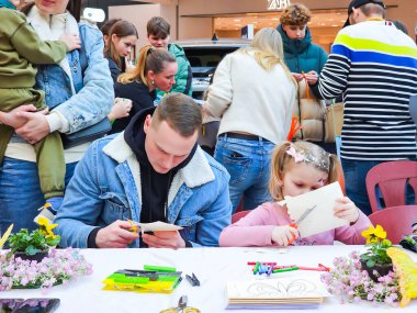 LATVIA, RIGA, SEPTEMBER, 29, 2025: Ebeveynler ve çocuklar Riga, Letonya 'da bir çocuk partisinde makaslarla kağıt kestiler.