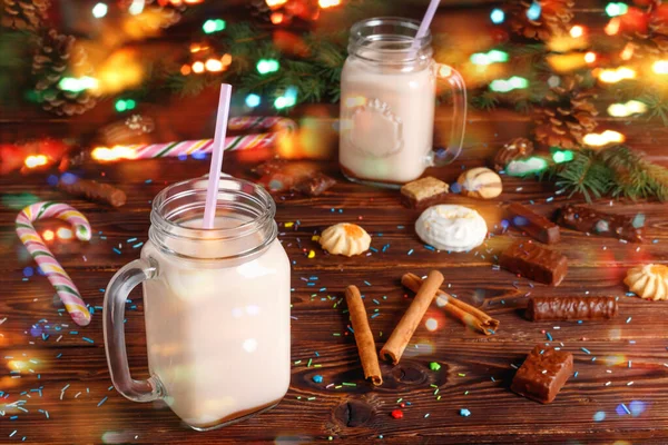 ミルク シナモン キャンディー ストローチューブ付きホットココアの2つのガラスカップクリスマスのモミやコーンを背景にぼかしボケ — ストック写真