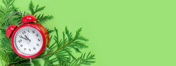 緑の紙の背景に木の枝と目覚まし時計 新年の5分前 クリエイティブグリーティングカー — ストック写真