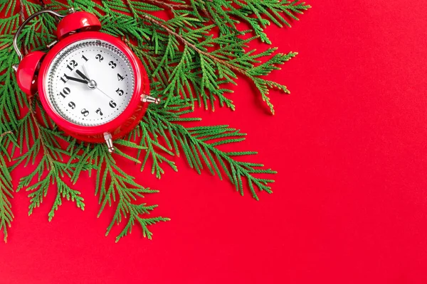 赤い紙の背景に木の枝と目覚まし時計 新年の5分前 創作グリーティングカード — ストック写真
