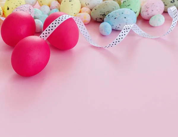 色彩艳丽的复活节贺卡 色彩艳丽的彩蛋和纸粉背景的彩带 图库图片