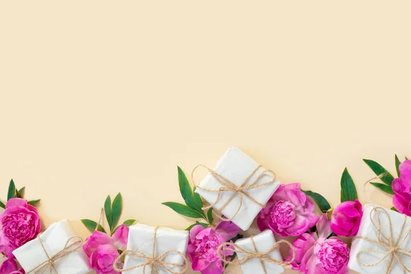 一束漂亮的粉红牡丹和礼品盒在黄色背景的包装纸上 节日贺卡 具有文本复制空间的创造性背景 — 图库照片