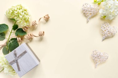 Bej arka planda hediye kutusu olan güzel ortanca buketi. Kalpli tebrik kartı. Metin için kopyalama alanı olan yaratıcı arkaplan.