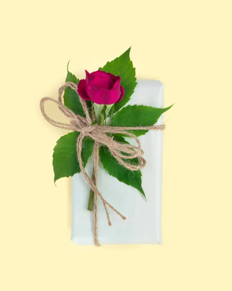 Set of wrapping paper and flowers for handmade on pink background. Homemade craft box gifts with  bouquet of red roses
