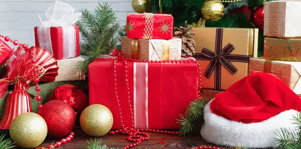 圣诞期间 圣诞桌上放有珠宝 玩具和圣诞老人帽的礼品盒 图库照片
