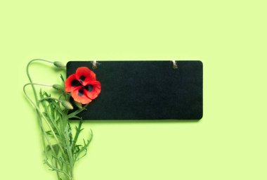 Anma Günü 'nde. Ahşap siyah çerçeve ve yeşil arka planda parlak kırmızı gelincikler..
