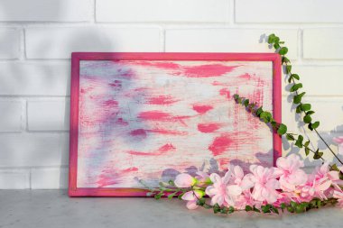 Ahşap vintage çerçeve ve bir buket pembe çiçek tuğla duvar arkasında. İç mimari