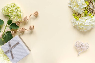 Bej arka planda hediye kutusu olan güzel ortanca buketi. Kalpli tebrik kartı. Metin için kopyalama alanı olan yaratıcı arkaplan.